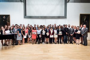 A group of twenty students and faculty pose holding certificates at the Closing Ceremony in Giessen, Germany.