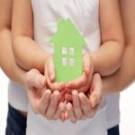 parent & child hands holding cut-out of house