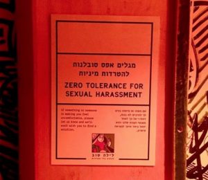 A paper flyer posted to a wall urges "Zero Tolerance for Sexual Harassment."