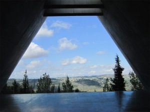 View looking out over the Israeli countryside of rolling hills and trees from within the Holocaust Memorial.