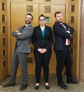 3 law students posing in a courthouse in professional dress