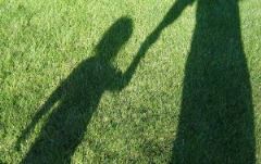 Shadows of child and adult holding hands
