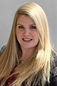 Head shot of a woman with long blonde hair; her name is Sarah Bondar