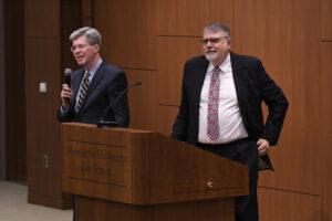 Thomas W. Merrill amd Joe Kearney at a podium.