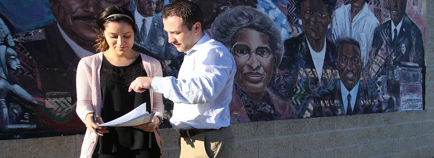 Two Students in Front of a Mural