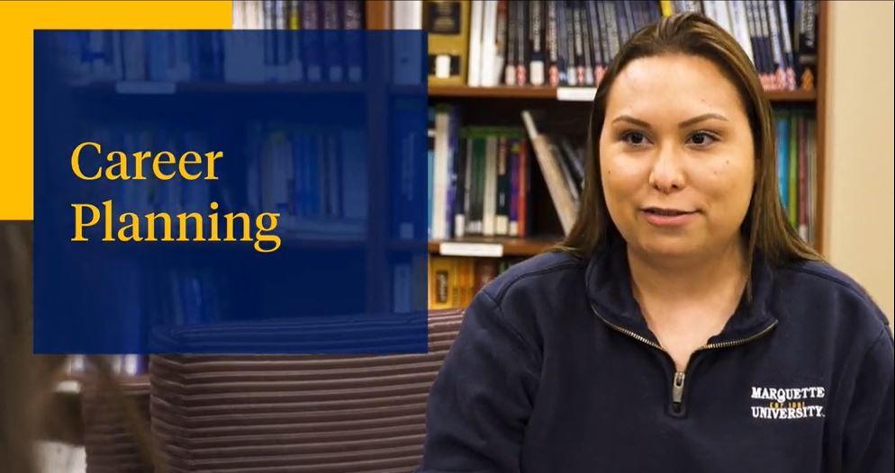 Student standing in front of books